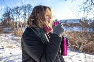 young-woman-enjoys-hot-drink-from-thermos-walk-winter_169016-17917